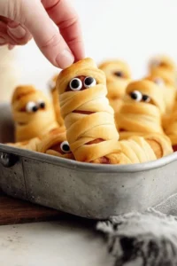 Mummy Pigs in a Blanket recipe with spooky wrapping for Halloween parties